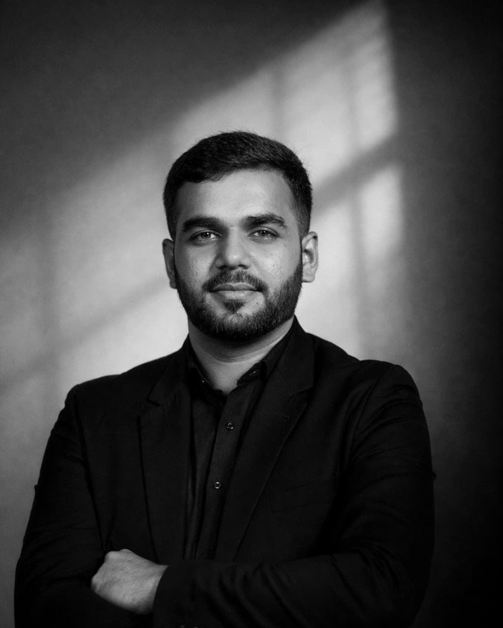 Kuraib Ali, Dubai SEO consultant and web designer, in a black jacket against a lit wall.